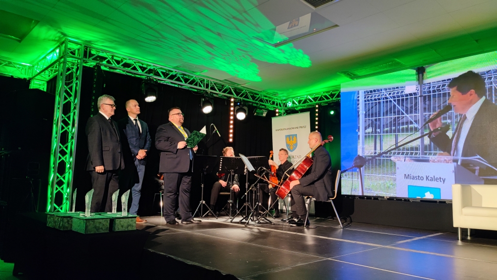wręczenie nagród Zielony Feniks, na scenie 3 osoby wręczające, Burmistrz Kalet oraz kwartet smyczkowy